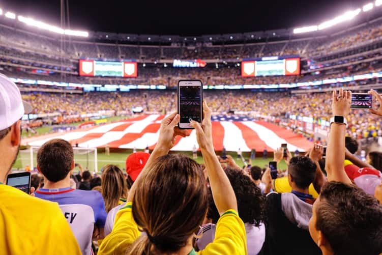 Filming the soccer game to be used as her the ringtone for her husband