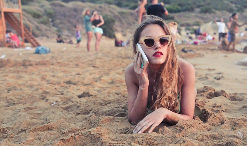 A girl enjoying CallApp on the beach