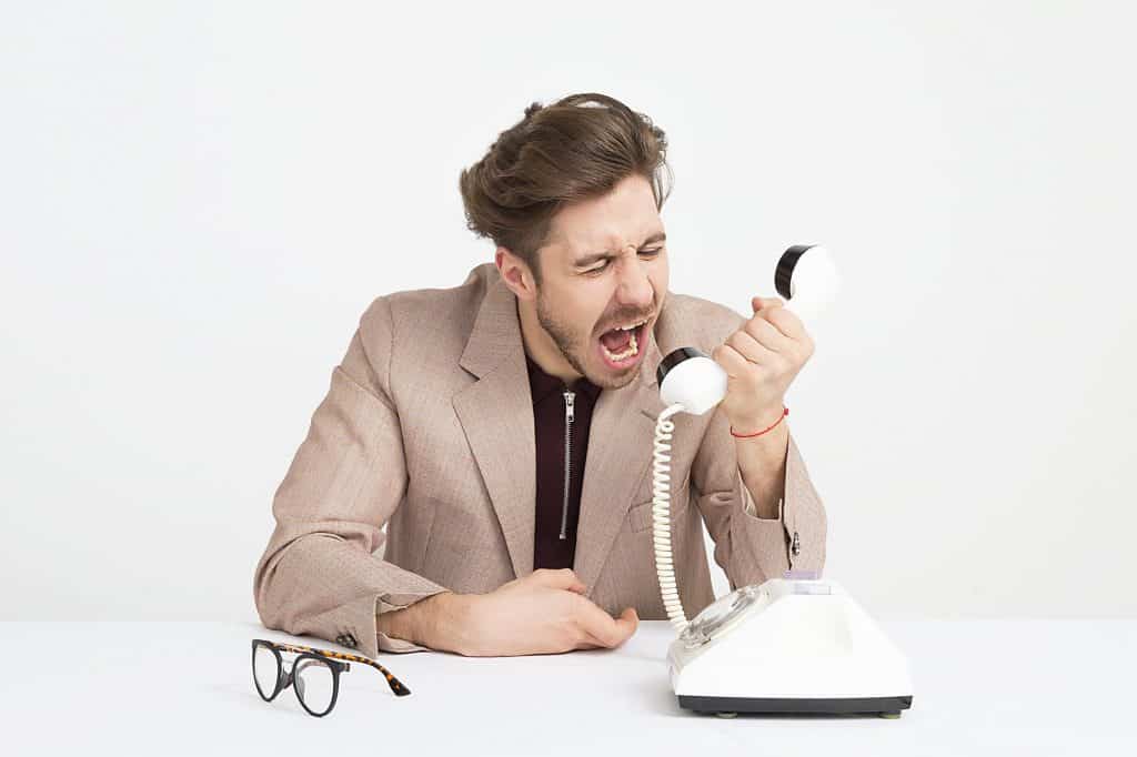 An angry man receiving a spam call