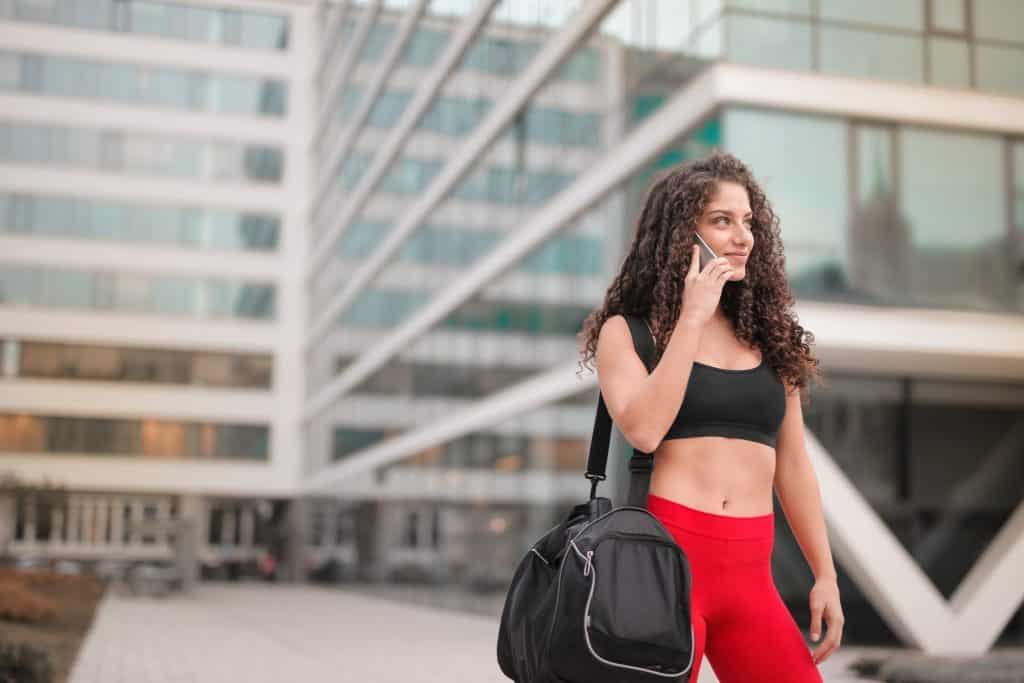 A girl talking on the phone as she leaves the gym