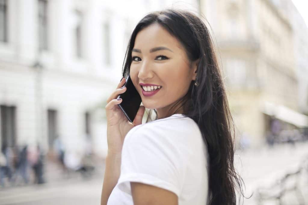 A pretty asian girl smiling on the phone