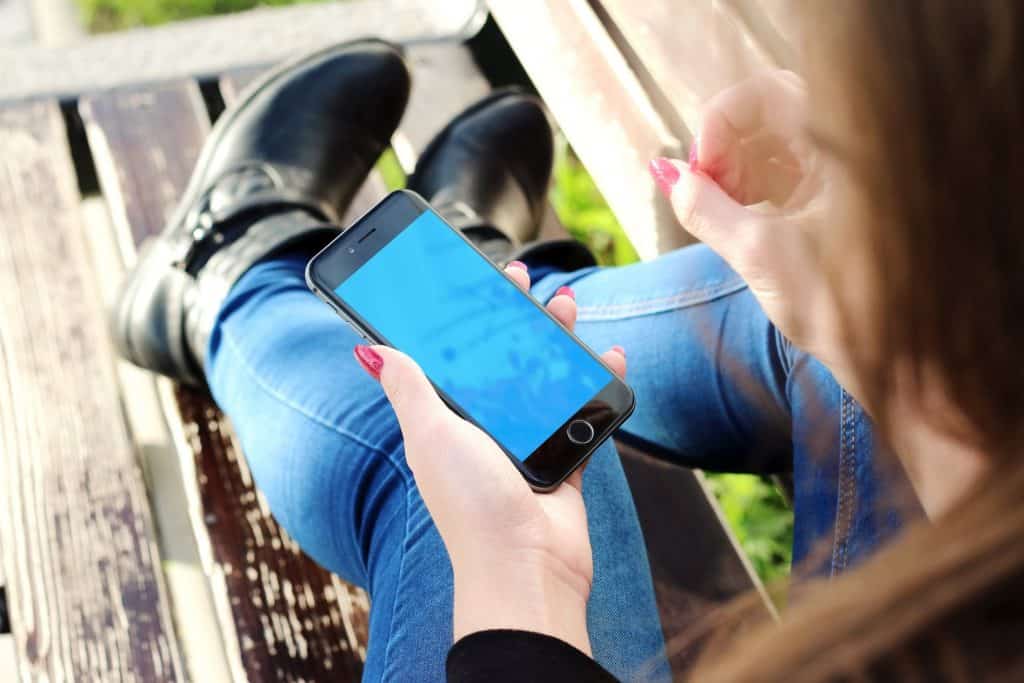 A girl holding a phone and enjoying the features offered to her. 