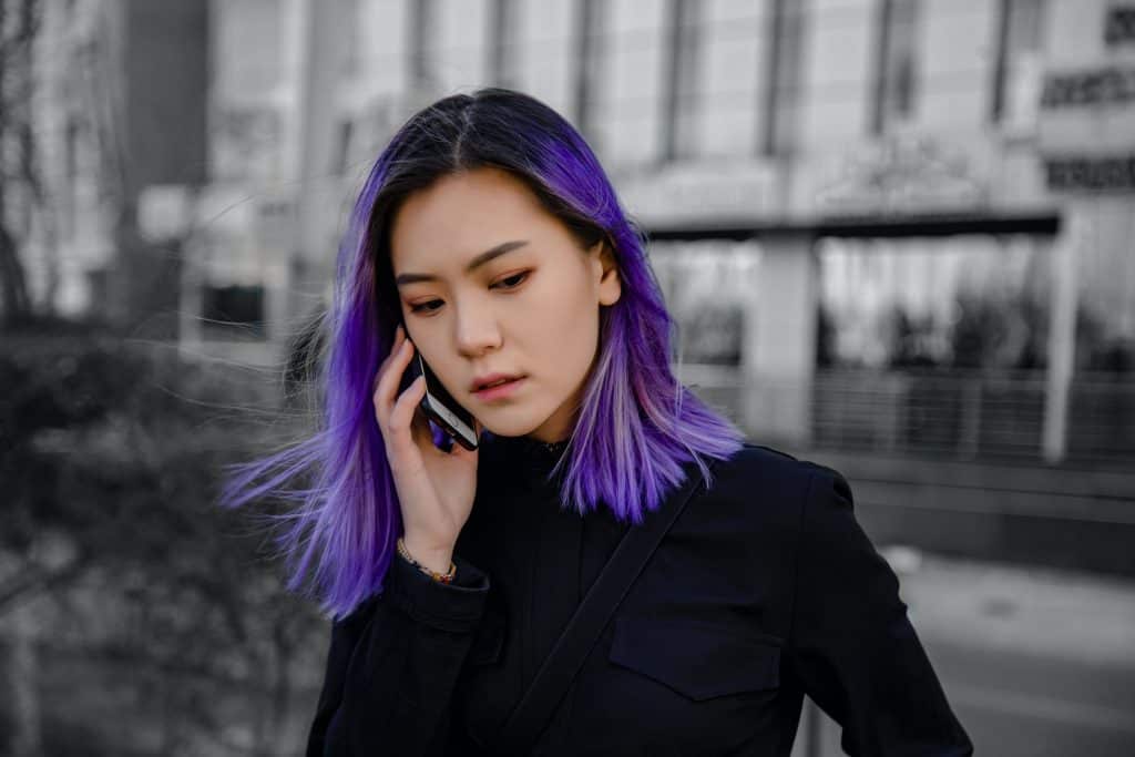 A girl with purple hair on the phone