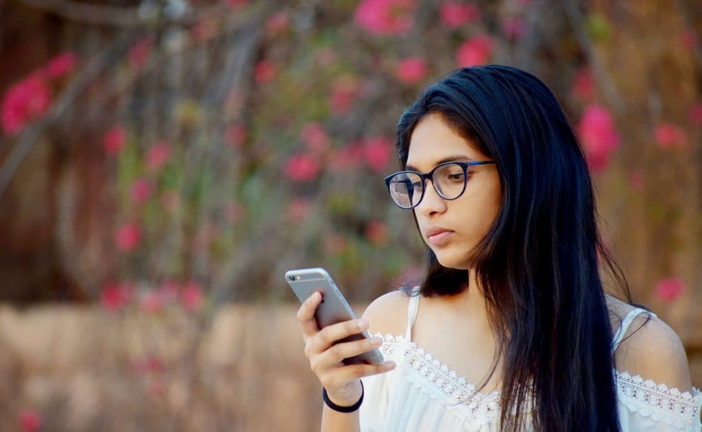 A girl holding her phone and looking concered