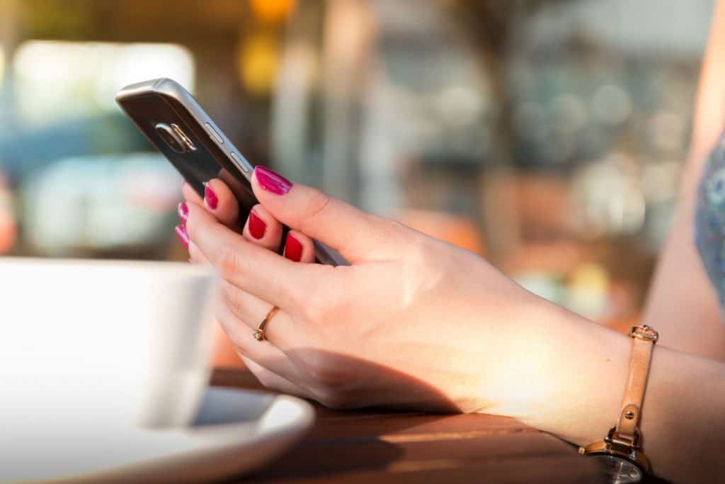 A girl with red nails holding a phone