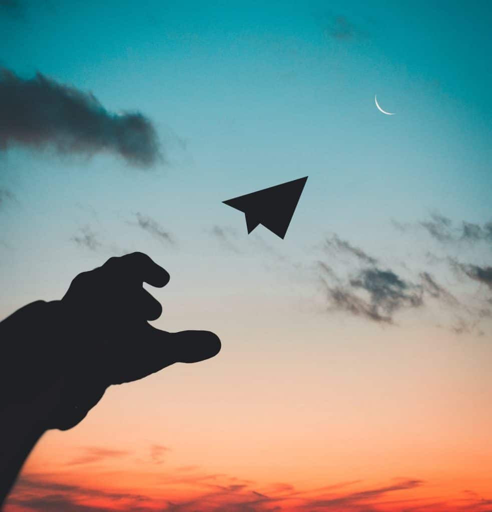 A paper plane being thrown into the sunset