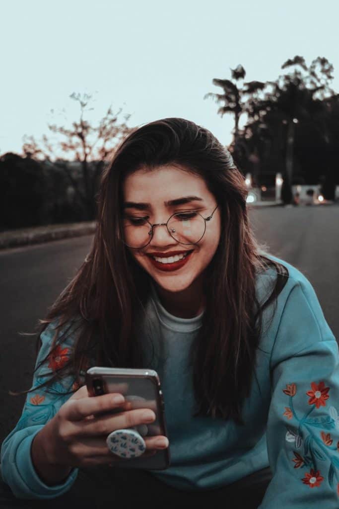 A girl smiling at her phone