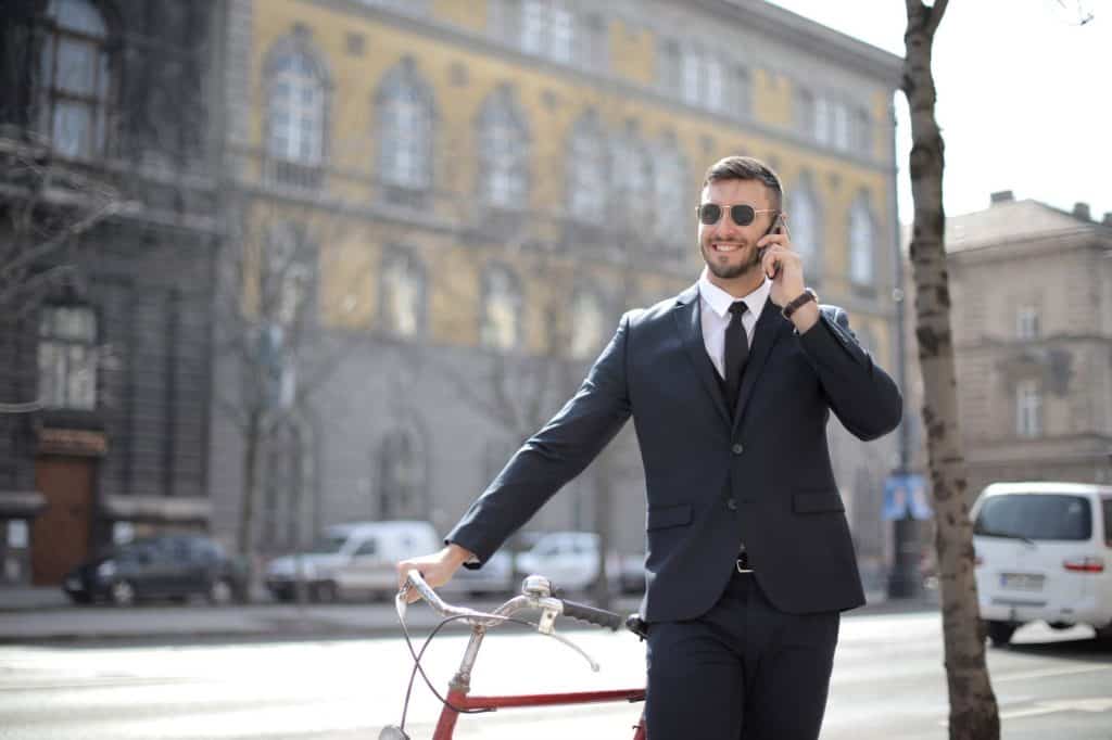 A businessman on the phone in front of a building 