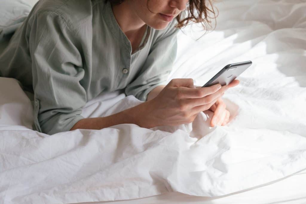 A woman using her smartphone in bed