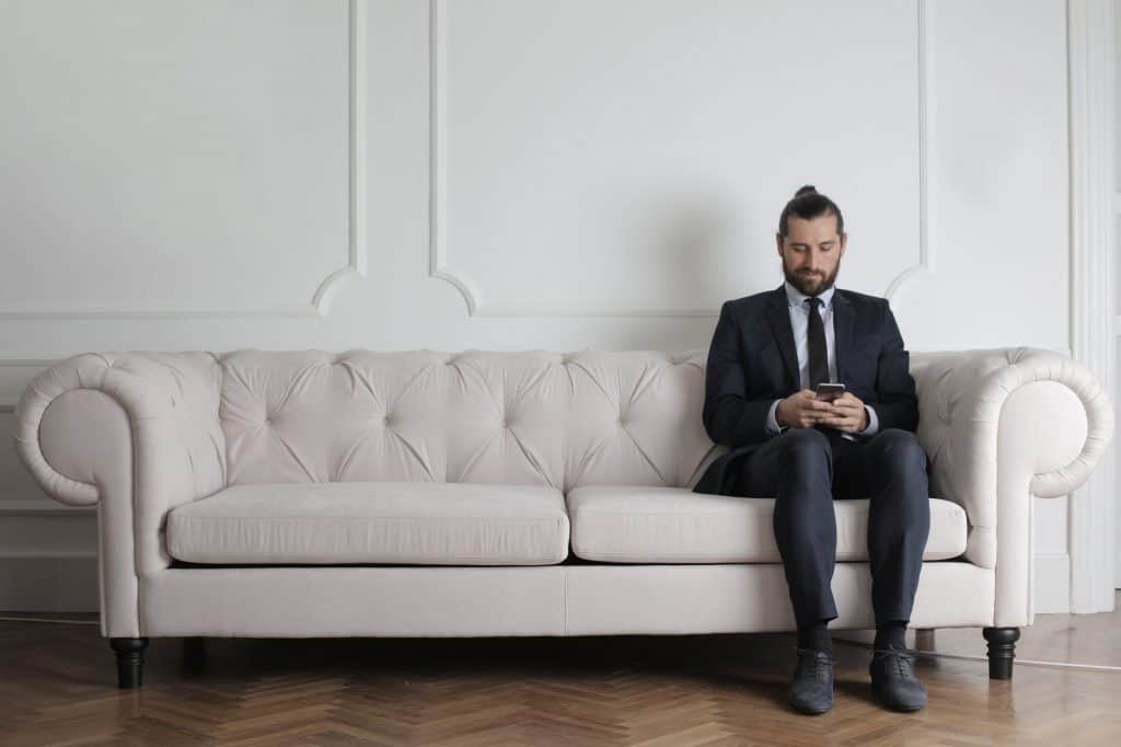 A businessman sitting on a white sofa