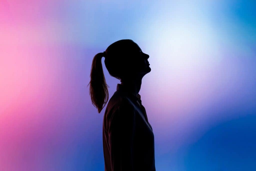 A silhouette of a woman on a pink and purple background