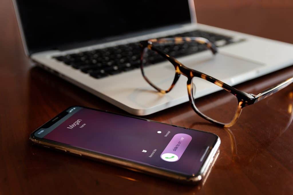 An iPhone ringing next to a laptop 