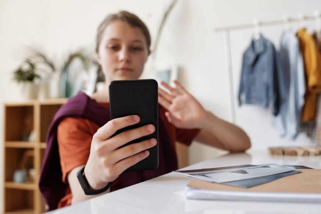 A girl holding a black smartphone