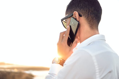 A man in a white shirt on the phone