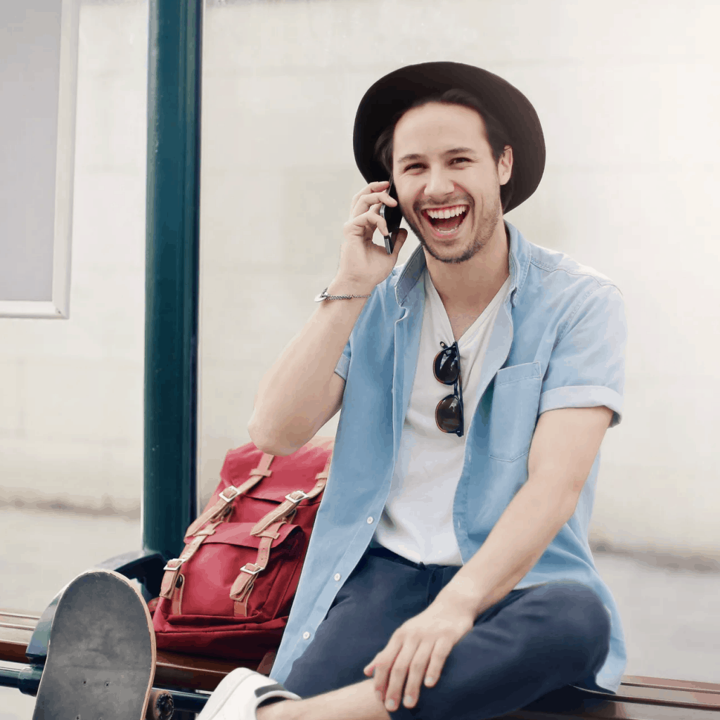 A trendy man smiling as he speaks on the phone