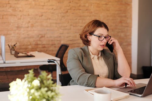 A woman at her desk using the phone