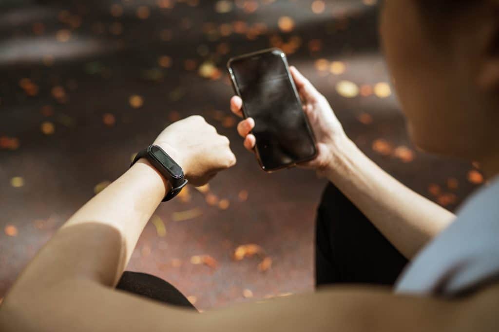 A woman using her phone and watch for health purposes