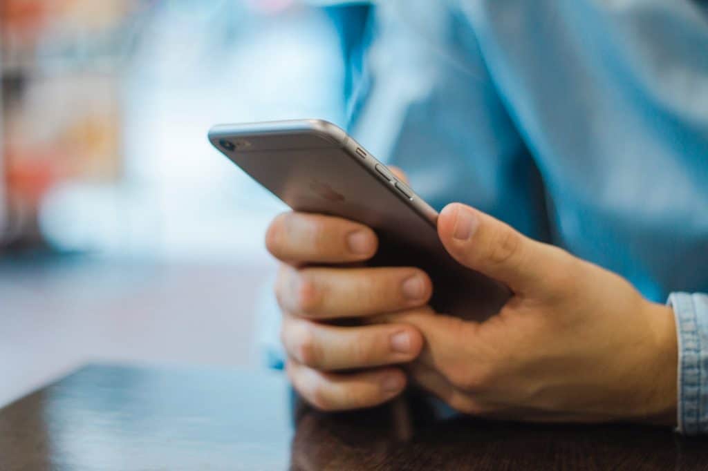 A person in a blue shirt holding a smartphone