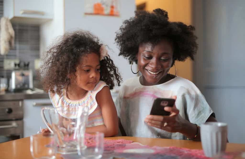 A mother and daughter holding a cellphone