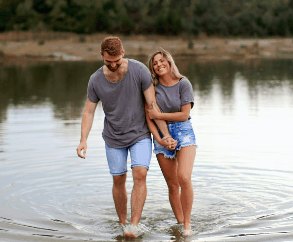 A happy couple standing together in a lake