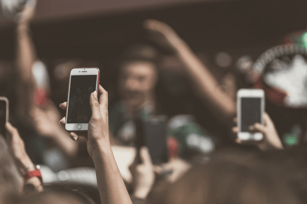 A group of people holding up their smartphones