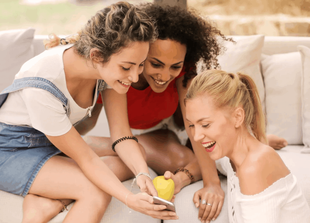 Three girls looking at a phone screen 