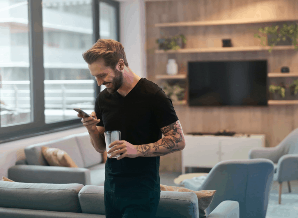 A man in a black t-shirt holding his phone 