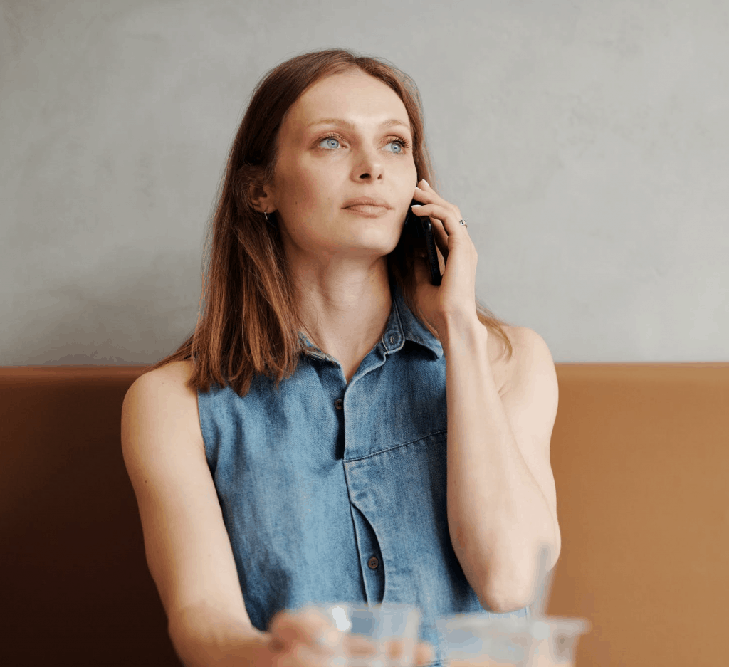 A woman in a denim shirt speaking on the phone