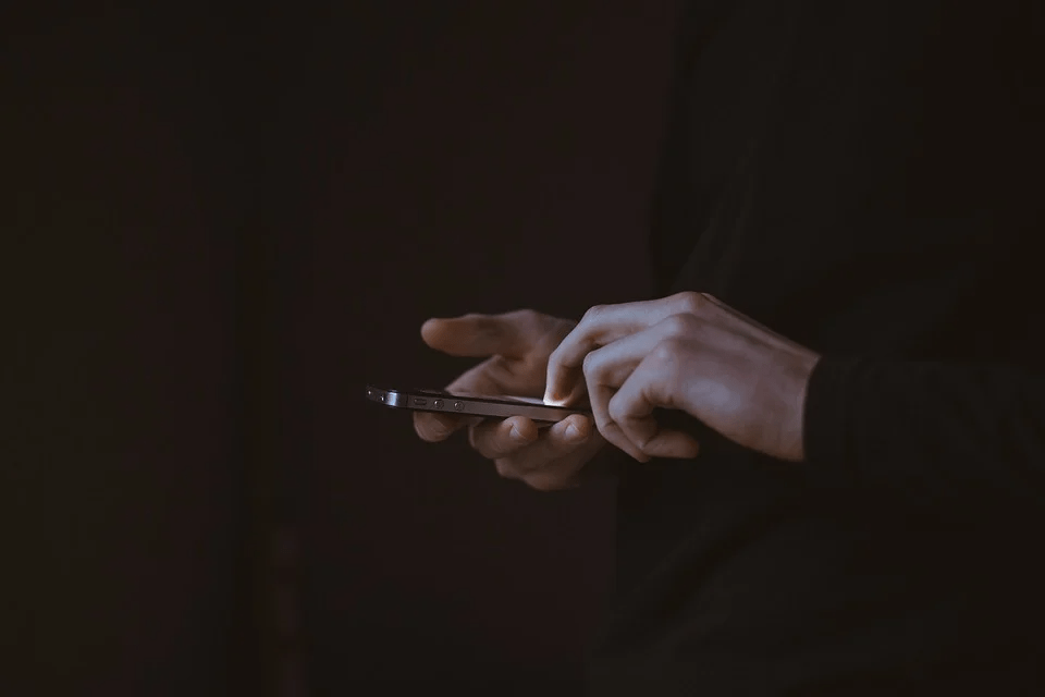 A man holding a phone on a black background 