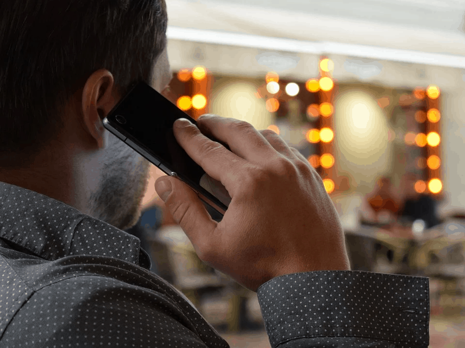 A man speaking on the phone in a shopping centere