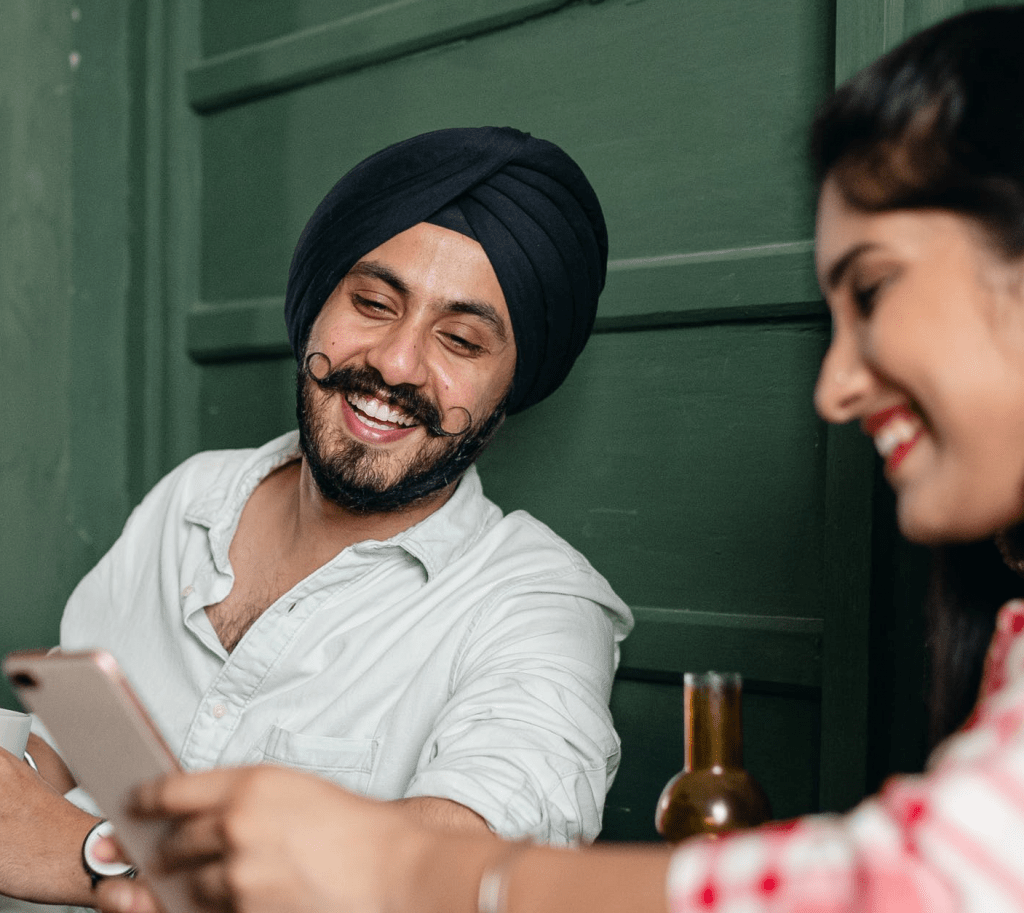 An Indian couple laughing and enjoy CallApp together 