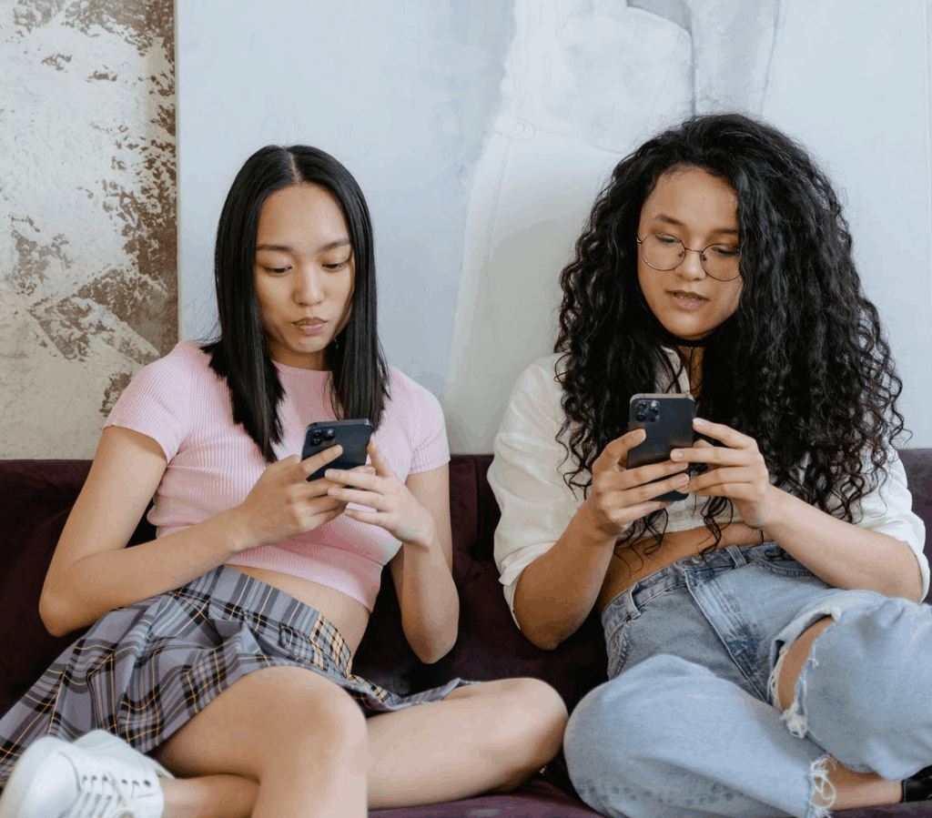 Two girls holding their phones 