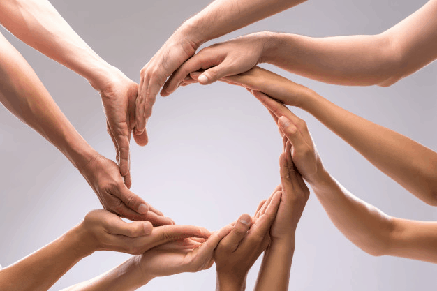 A group of people holding their hands together 