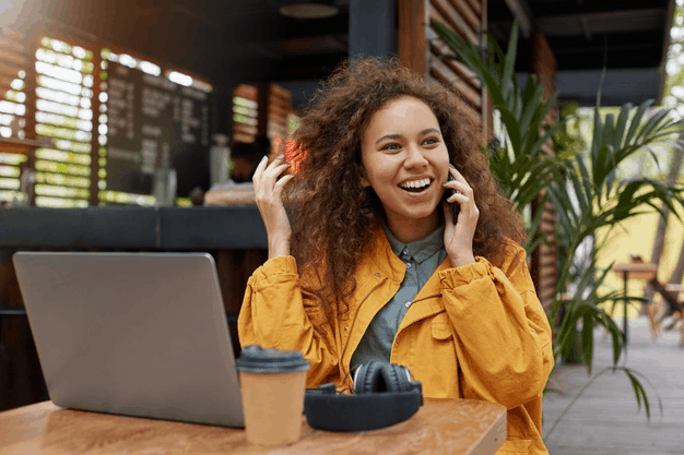 A young curly haired girl speaking on the phone with CallApp